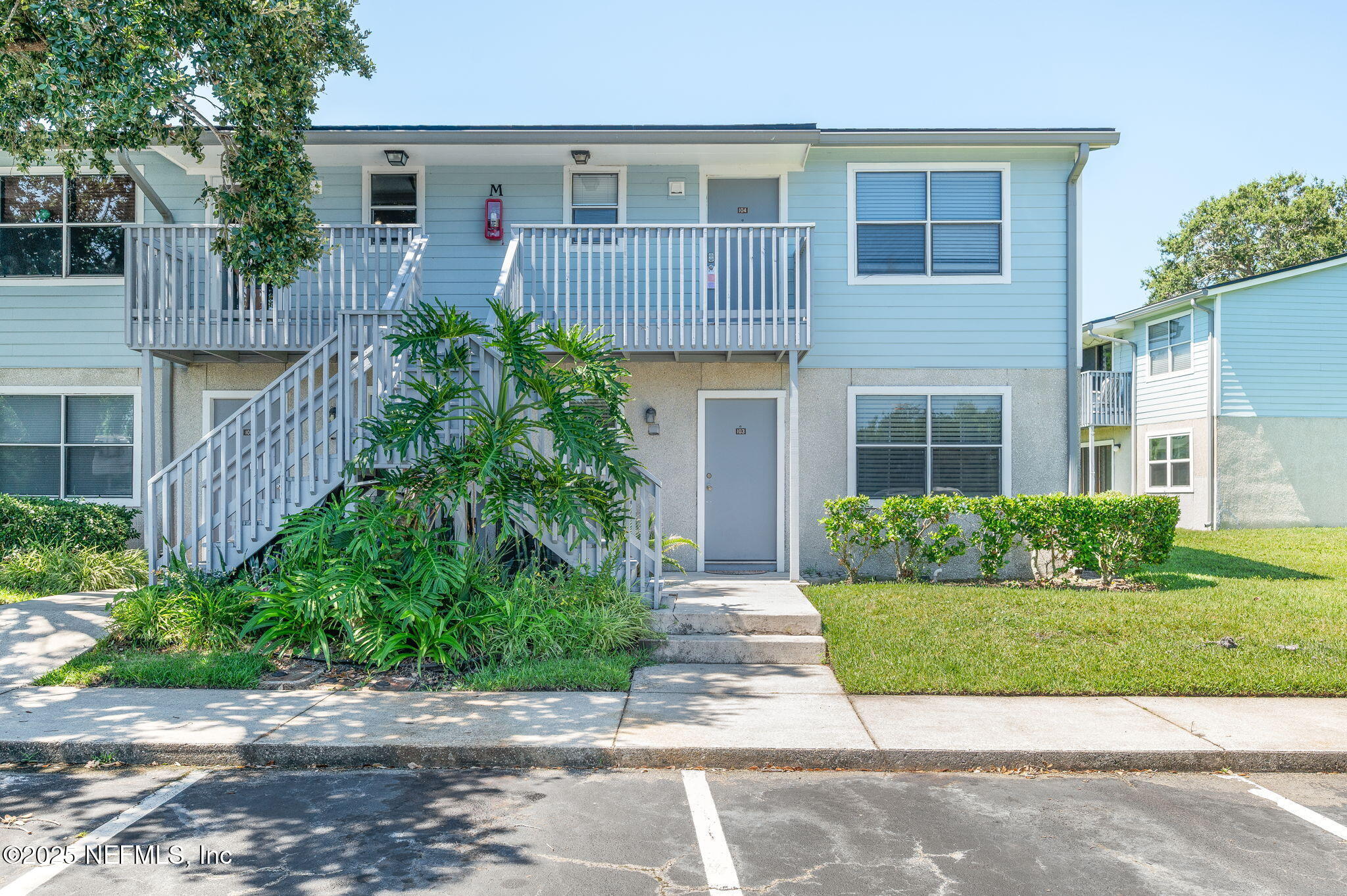 700 West Pope Road, Unit M103 St. Augustine, FL 32080 - Photo 2 of 30 a view of a brick house with a yard plants and large tree