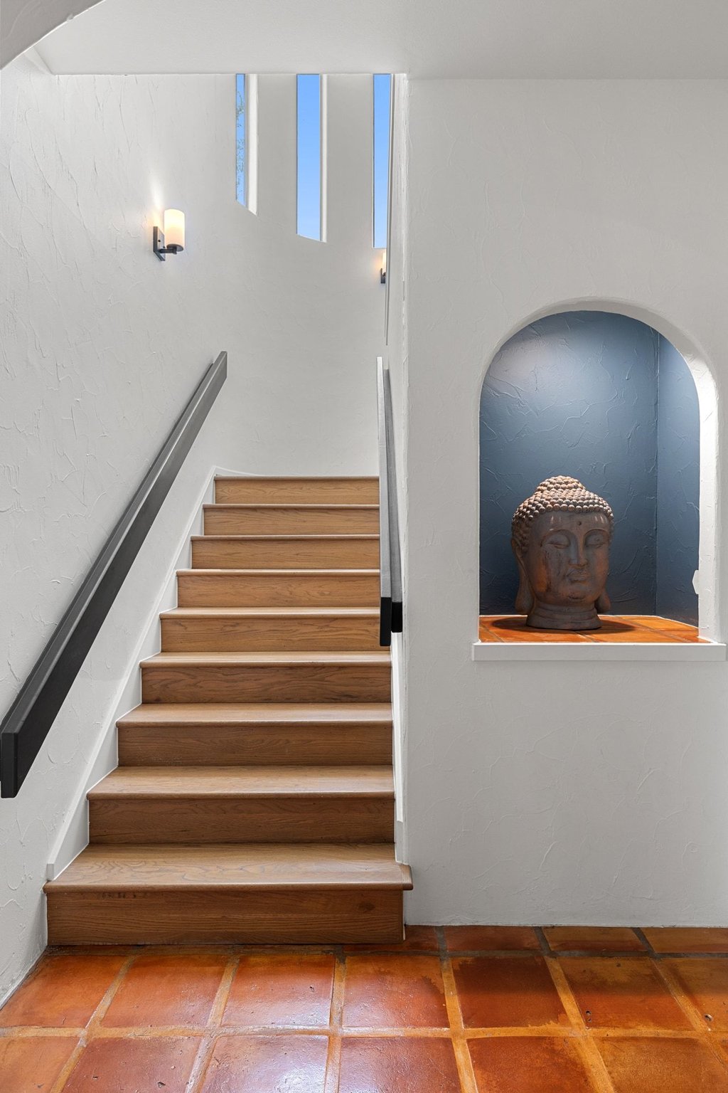 716 North Commons Ford Road Austin, TX 78733 - Photo 9 of 30 Staircase featuring natural wood treads, a matte black handrail, and white risers