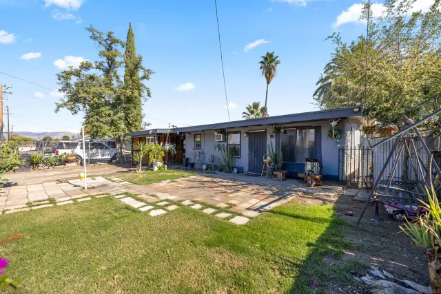 a view of a house with backyard and sitting area