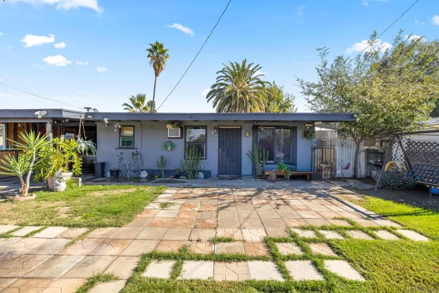 a view of a house with backyard and sitting area