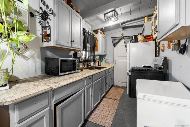 a kitchen with granite countertop a sink stainless steel appliances a counter space and cabinets