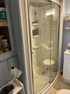 a bathroom with a glass shower door and a toilet
