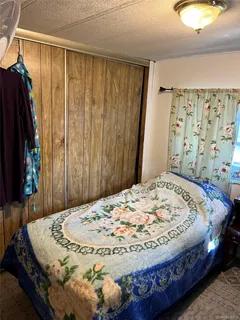 a bed sitting in a bedroom next to a window and a bathroom