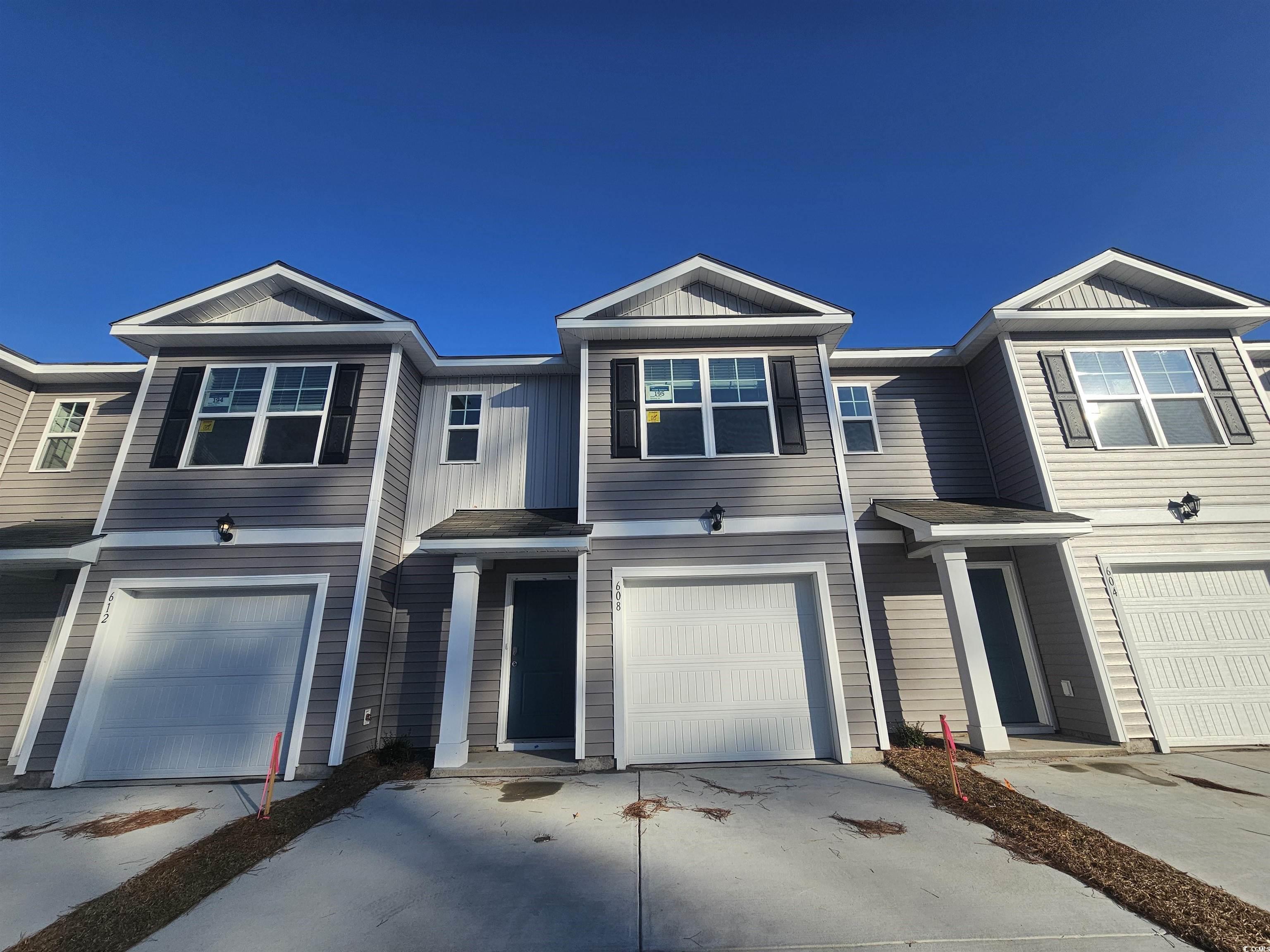 View of front facade featuring concrete driveway and a garage