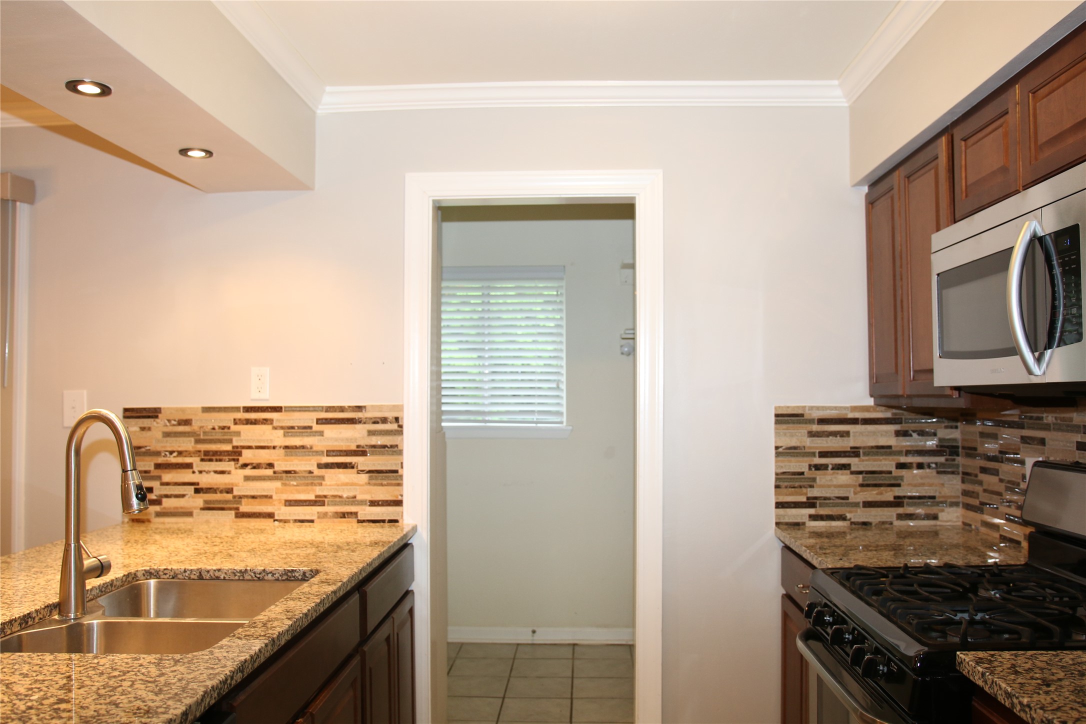 700 Castle Ridge Road, Unit A Austin, TX 78746 - Photo 11 of 34 a kitchen with granite countertop a sink and a stove