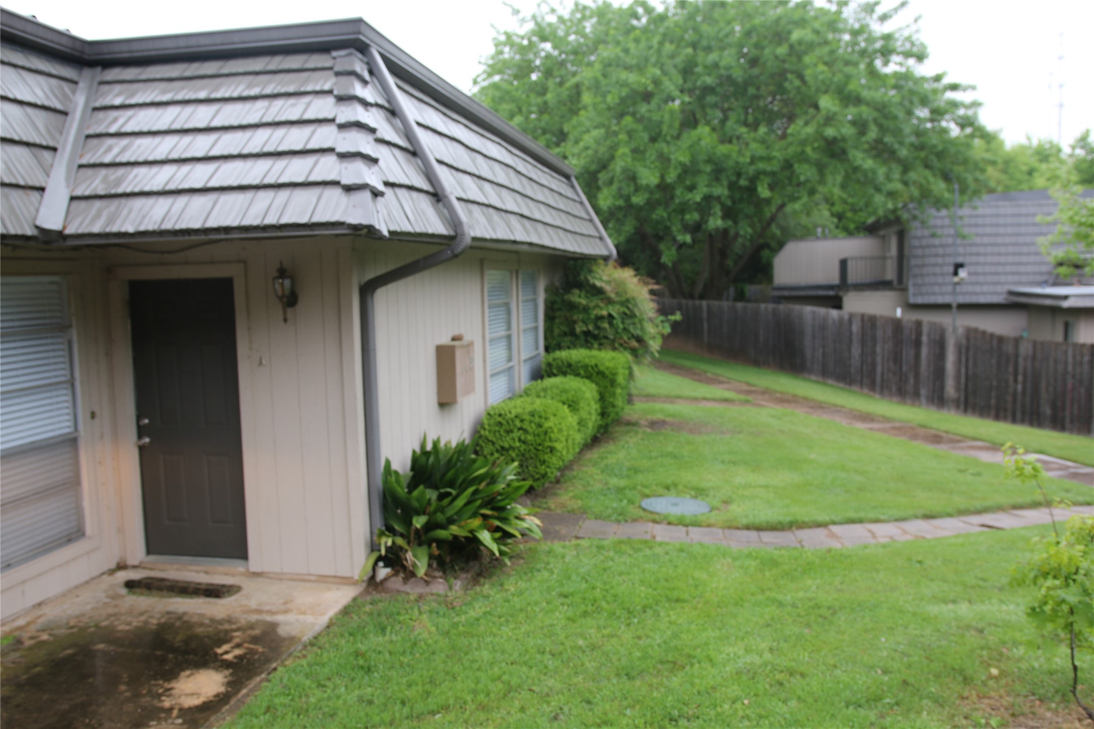 700 Castle Ridge Road, Unit A Austin, TX 78746 - Photo 3 of 34 a backyard of a house with plants and wooden fence