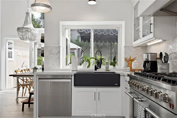 a kitchen with a refrigerator a stove and a dining table with wooden floor