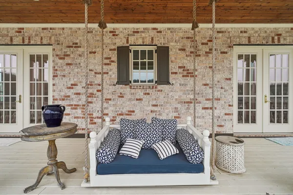 a dining room with wooden floor a chandelier a glass table and chairs