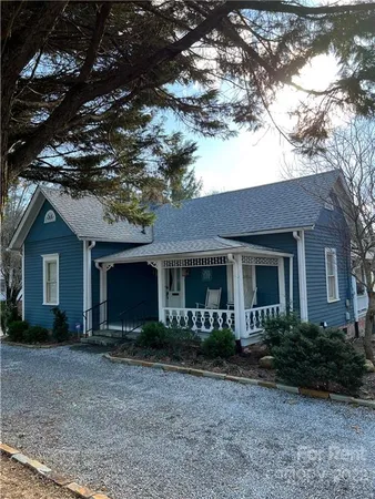 a front view of house with yard and trees in the background