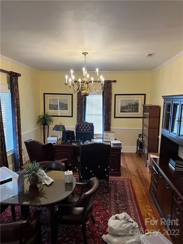a living room with furniture and a dining table with bookshelf