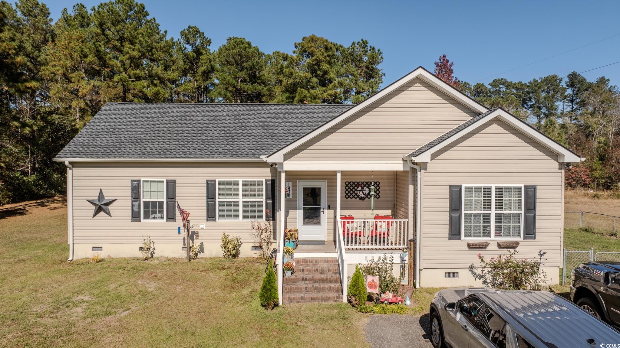 Front of the home featuring a porch, and large yard