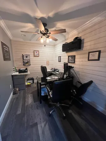 a living room with furniture a rug and a ceiling fan