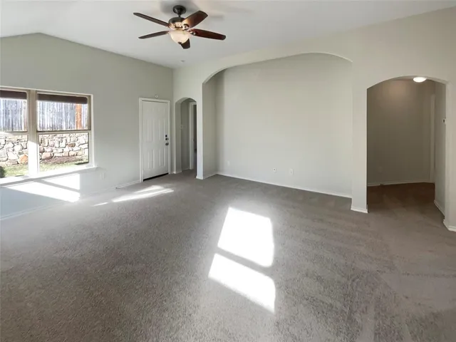 a view of a livingroom with a ceiling fan and window