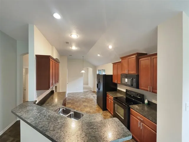 a kitchen with stainless steel appliances granite countertop a sink stove and refrigerator
