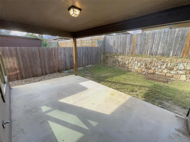 a view of backyard with wooden fence