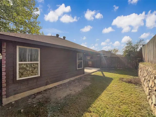 a view of backyard with wooden fence