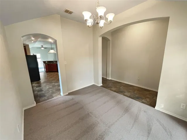 an empty room with wooden floor and staircase