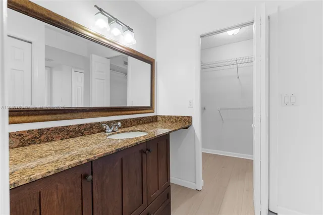 a bathroom with a granite countertop sink and a mirror
