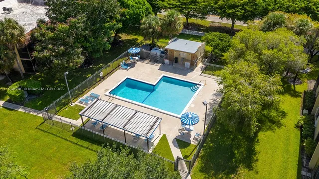an aerial view of a house with swimming pool and outdoor seating