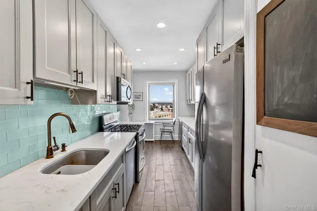 a kitchen with stainless steel appliances granite countertop a refrigerator and a sink