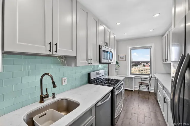 a kitchen with stainless steel appliances a sink stove and cabinets