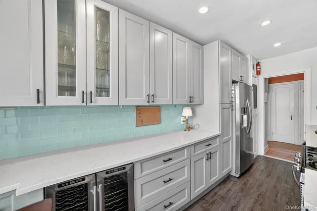 a kitchen with stainless steel appliances white cabinets and a refrigerator