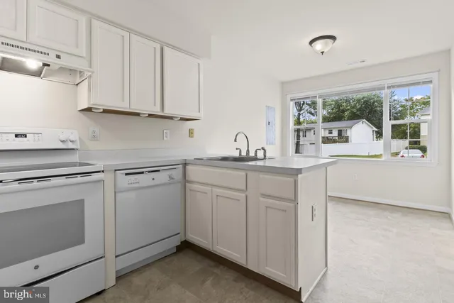 a kitchen with white cabinets and white appliances