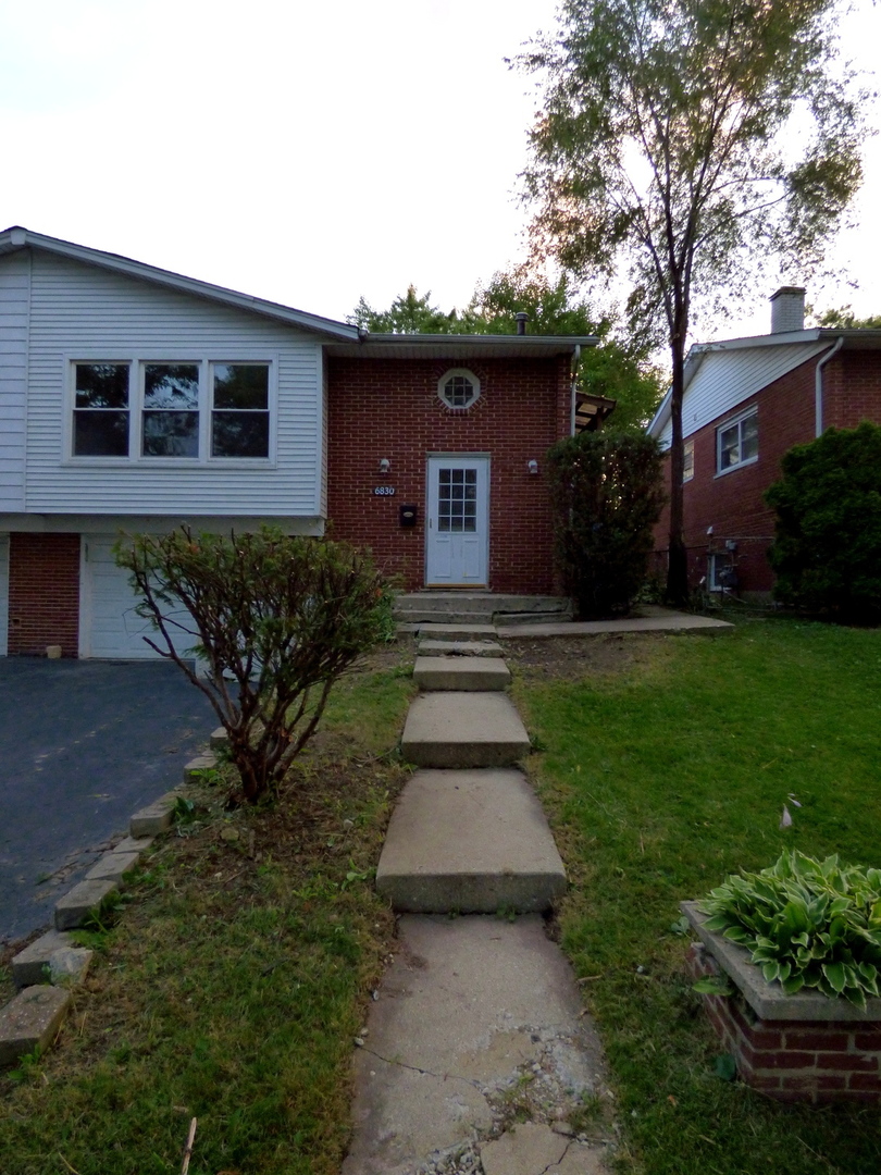 6830 Valley View Road Hanover Park, IL 60133 - Photo 2 of 8 a front view of a house with garden
