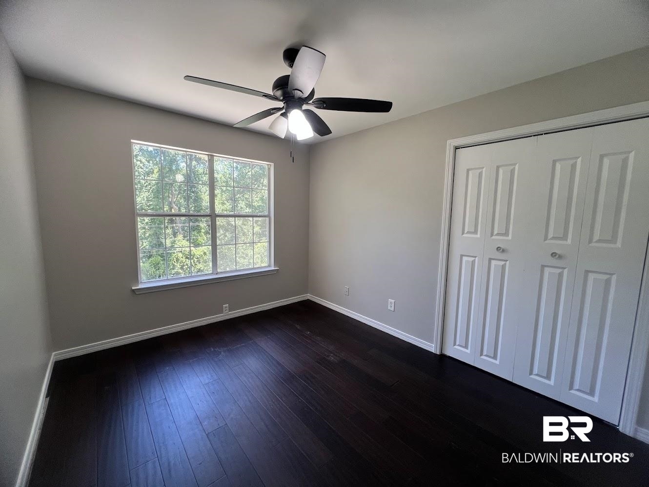 266 Ridgewood Drive Daphne, AL 36526 - Photo 18 of 34 Room featuring dark wood-finish flooring, a ceiling fan with integrated lighting, and a window with white trim
