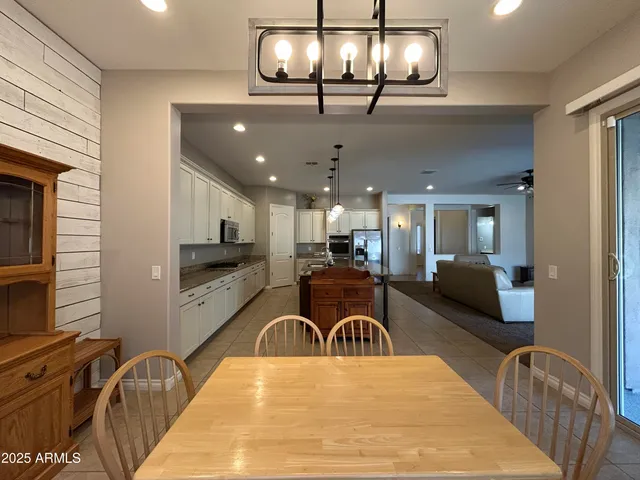 a kitchen with stainless steel appliances kitchen island granite countertop a stove top oven a dining table and chairs with wooden floor