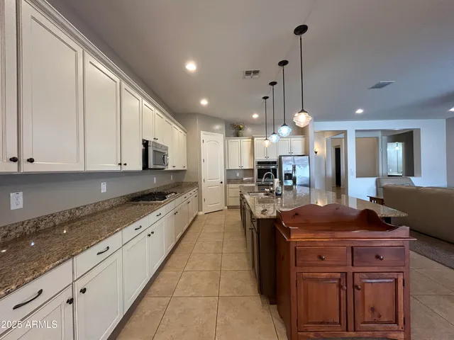 a kitchen with stainless steel appliances granite countertop a stove a sink and a refrigerator