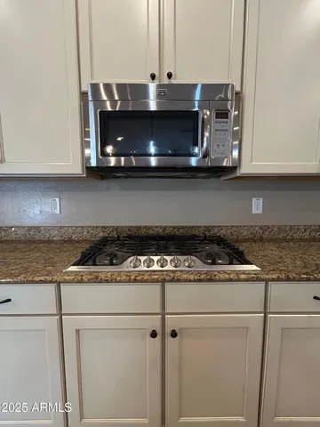 a kitchen with stainless steel appliances granite countertop a stove and a microwave with granite countertops