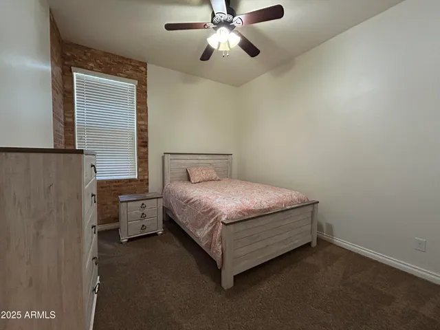 a bedroom with a bed and a ceiling fan