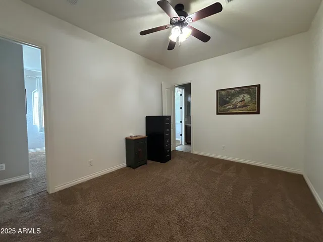 a view of an empty room with a ceiling fan