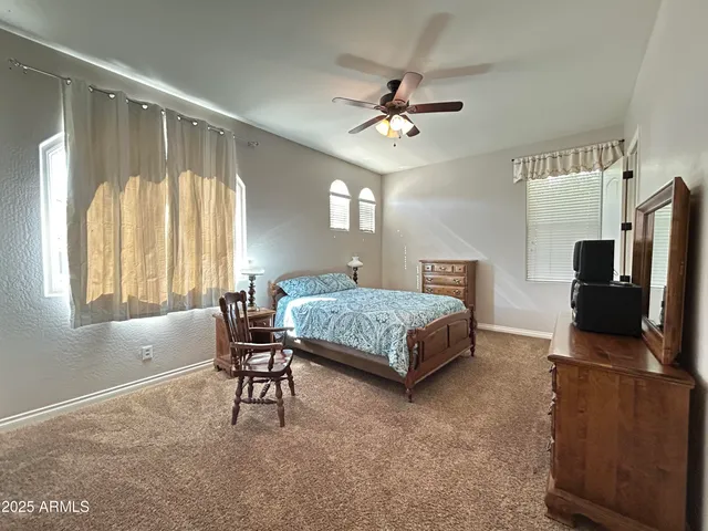 a bedroom with a large bed a chandelier and dresser