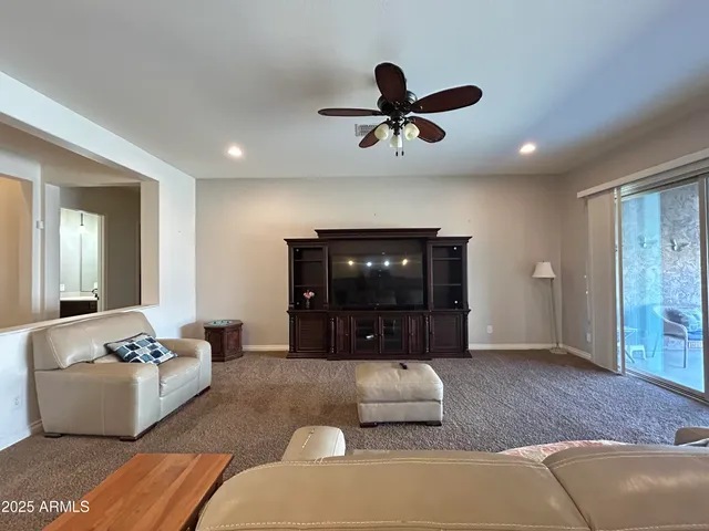 a living room with furniture and a ceiling fan