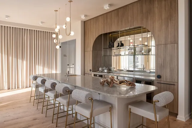 a kitchen with a dining table chairs cabinets and stainless steel appliances