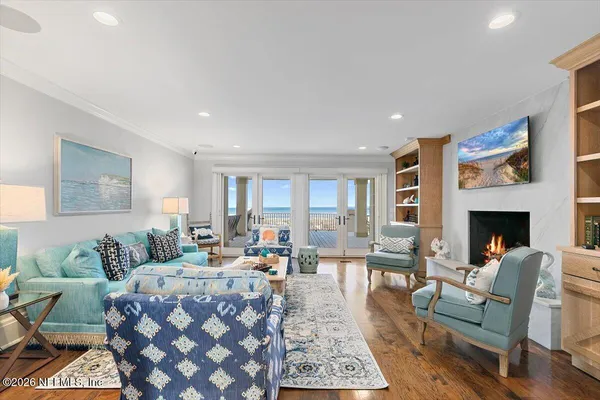 a view of a patio with lawn chairs floor to ceiling window and an outdoor kitchen
