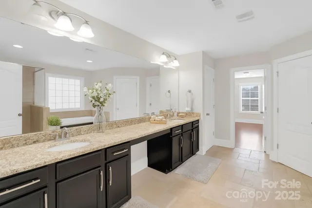a spacious bathroom with a granite countertop double sink and a mirror