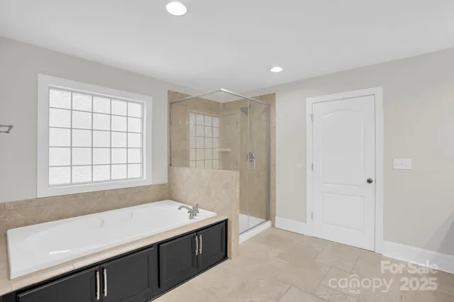 a spacious bathroom with a tub shower and sink