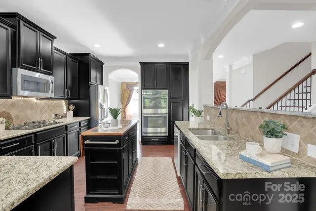 a kitchen with stainless steel appliances granite countertop a sink stove and refrigerator