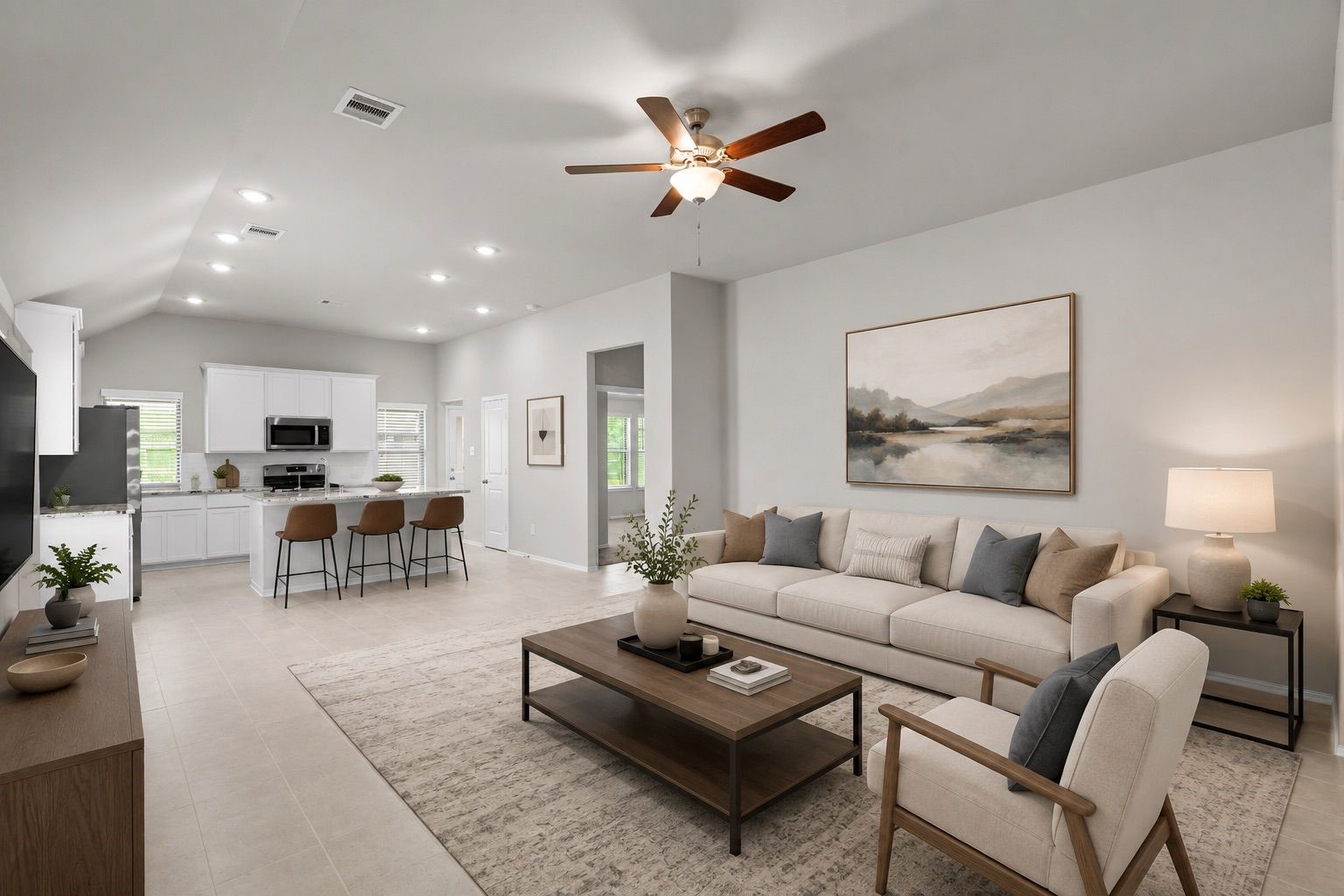 2011 Oak Leaf Court Manvel, TX 77578 - Photo 6 of 28 Modern, open-concept living space with a neutral color palette. The living room features a comfortable seating area and stylish decor, while the adjacent kitchen includes sleek white cabinetry, a breakfast bar with stools, and stainless steel appliances. Ceiling lights and a fan add to the bright, airy ambiance.