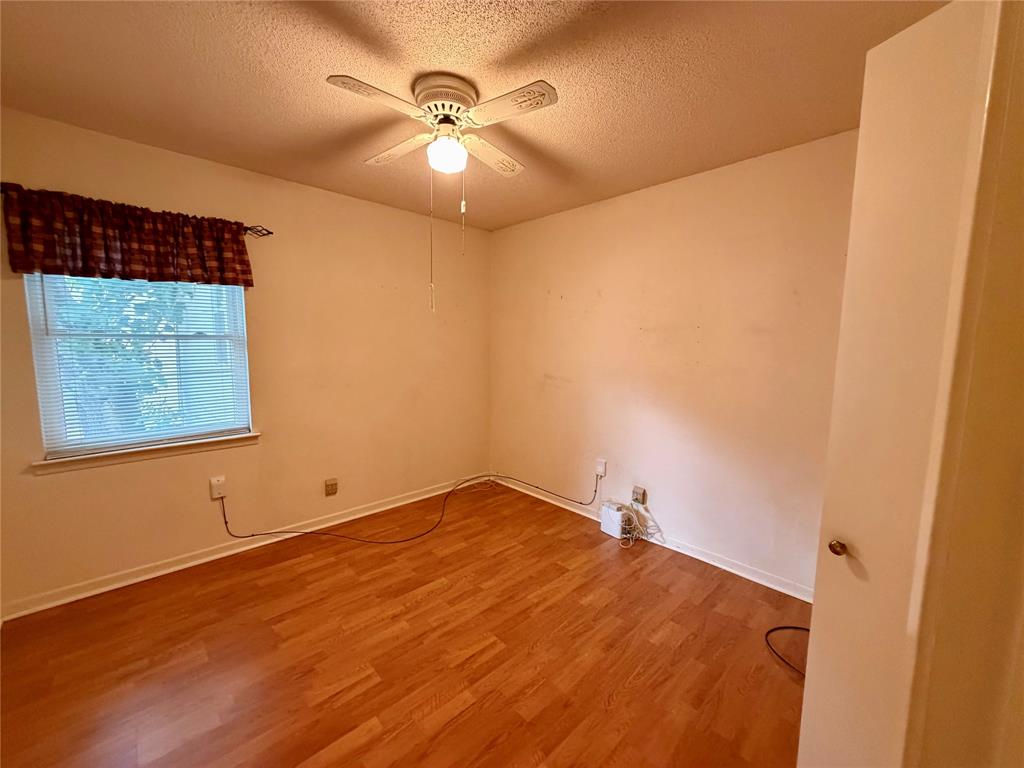 2030 Sycamore Street Paris, TX 75460 - Photo 14 of 24 Bedroom featuring wood-finish flooring, a window with blinds, and a ceiling fan with integrated lighting