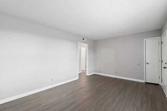 a view of an empty room with wooden floor