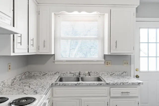 a kitchen with a stove and white cabinets