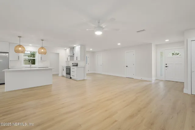 a large kitchen with kitchen island granite countertop wooden floor stainless steel appliances and cabinets