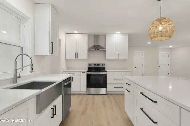 a kitchen with white cabinets and stainless steel appliances