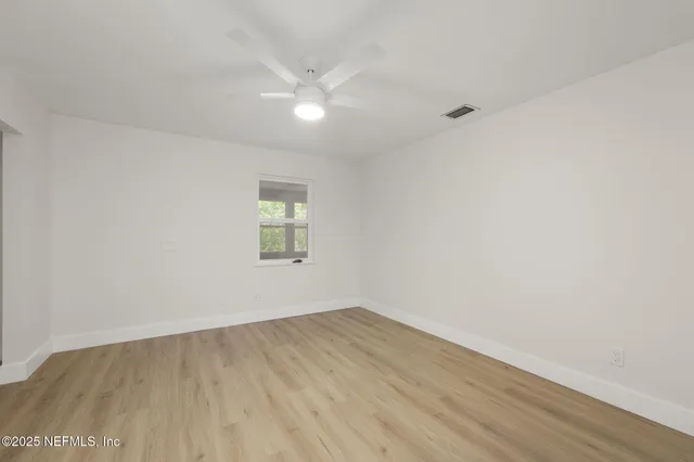 a view of an empty room with wooden floor
