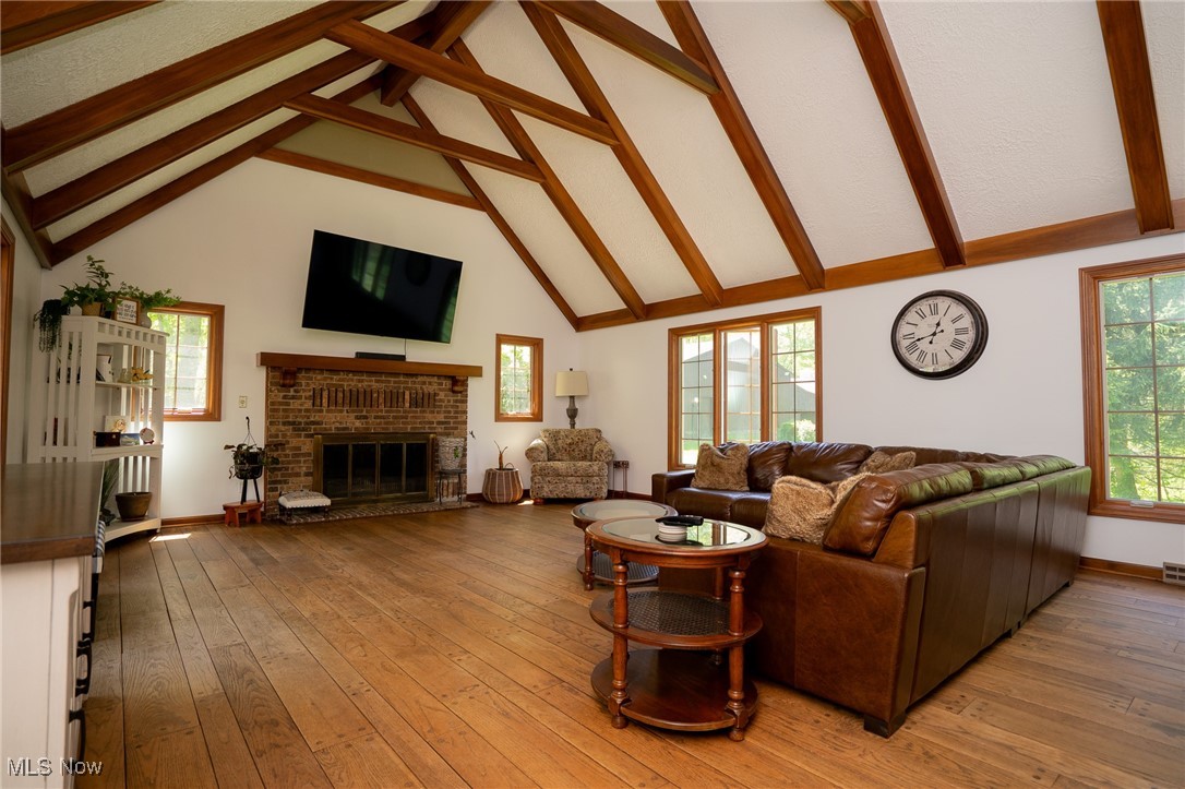 7780 Knauf Road Canfield, OH 44406 - Photo 5 of 48 Great Room featuring beam ceiling, a brick fireplace, light wood-style floors, high vaulted ceiling, and baseboards