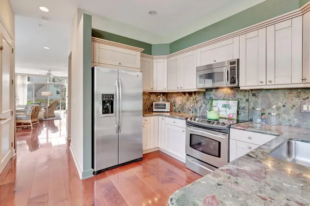 a kitchen with stainless steel appliances granite countertop a stove and white cabinets